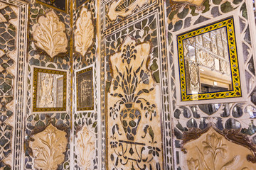 details of walls in rich decorated Amber fort in Jaipur, India