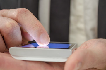 Finger of a businessman pointing at touch screen