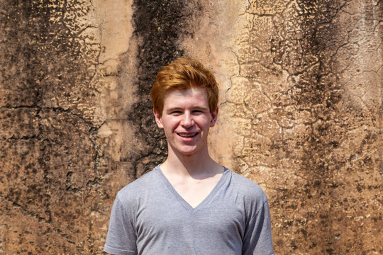 Portrait Of 16 Years Old Boy With Red Hair With Grunge Backgroun