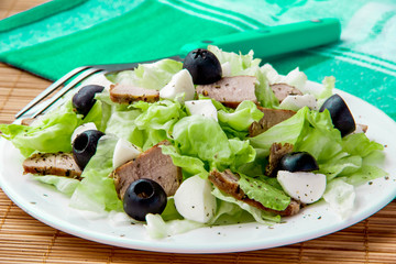 Fresh salad with lettuce, meat and olives