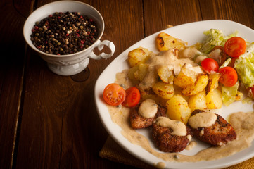 beef in pepper sauce with roasted potatoes and salad