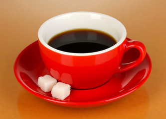 A red cup of strong coffee on beige background