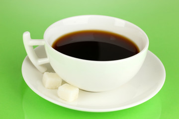 A cup of strong coffee on green background