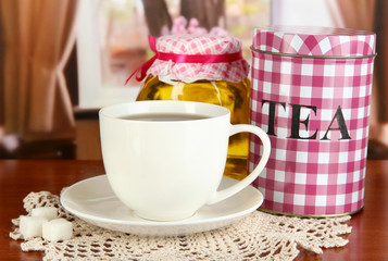 Jar and cup of tea on table in room