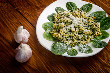 pasta with spinach on a wooden table