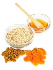 oatmeal in a glass bowl and dried fruits and honey