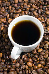 A cup of coffee with coffee bean as background