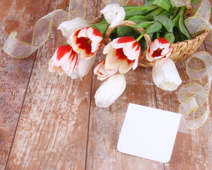 Tulips and blank card on a wooden board