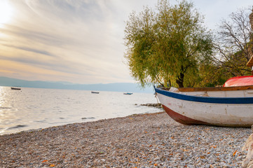 Obraz premium White boat at the stony beach in Ohrid lake coast Macedonia