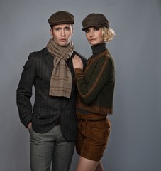 Elegant couple in caps isolated on grey background