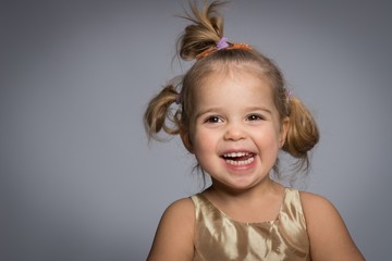 Smiling little girl isolated on grey