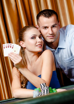 Couple playing poker at the gambling house