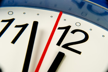 Extreme closeup clock hands about to hit midnight or noon