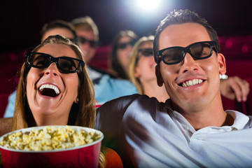 Young people watching 3d movie at movie theater