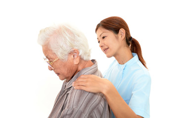 高齢者の肩もみをする介護士