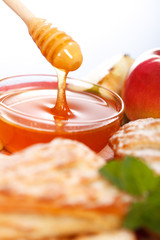 Macro of pouring honey behind cakes