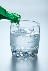 Mineral water pouring into glass