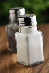 Salt and pepper shakers on a wooden background.