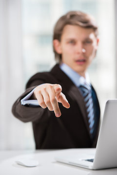 Portrait of adult business man pointing at you at his office