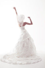 Fototapeta na wymiar Panna młoda w białej sukni ślubnej, widok z tyłu, podniósł ręce do góry. Biały