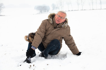 Senior man with injured leg on snow
