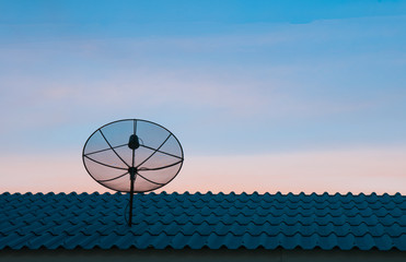 Satellite dish in sunset sky
