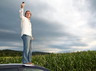 Mann steht auf Autodach ohne Netzabdeckung