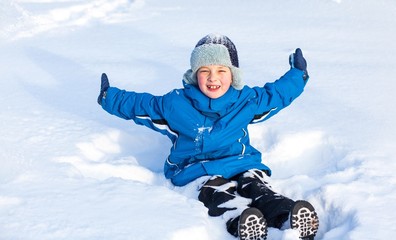 Fototapeta na wymiar happy boy is playing with snow