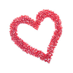 ripe pomegranate seeds in form of heart isolated on white backgr