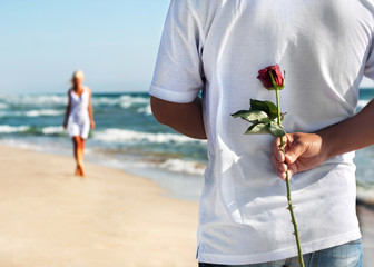 the romantic date concept - man with rose waiting his woman on t