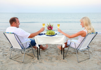 Fototapeta premium A young couple share a romantic dinner with candles and wine gla