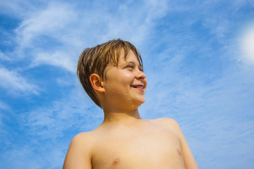 happy young boy with brown hair  enyoys the tropical beach