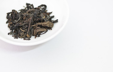 Dry tea leaves on a white background