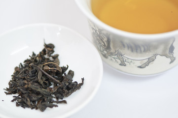 Cup of chinese tea with dry tea leaves isolated