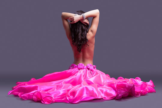 topless dancer in pink costume sitting on floor