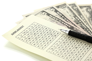 Fototapeta premium Lottery ticket with pen and money, isolated on white