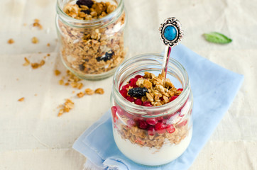 Yoghurt in a glass jar with muesli and currant