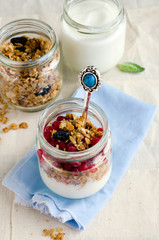 Yoghurt in a glass jar with muesli and currant