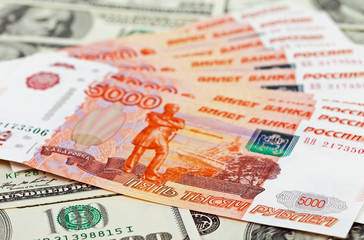 Russian roubles bills laying over dollars background