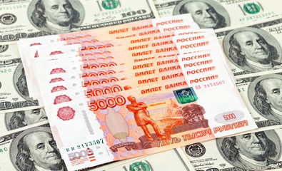 Russian roubles bills laying over dollars background