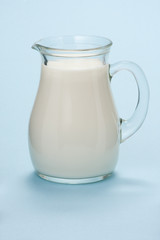 Jug with fresh milk on a blue