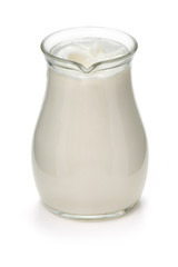 Jug with fresh milk on a white
