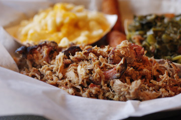 A serving of pulled pork with side dishes