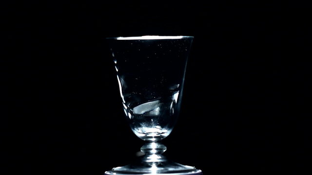 white figured glass rotates on a black background