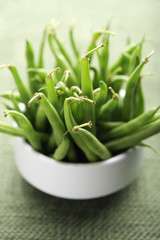 Green beans in a white bowl, selective focus.