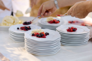 Waiter serving plates with dessert