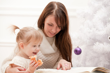 Beautiful woman showing a book to child