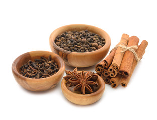 Spices in a wooden bowl on a white background