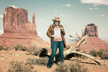 blond cowgirl holding wanted paper