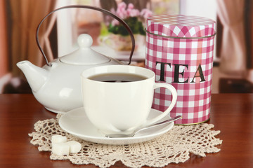 Jar and cup of tea on table in room